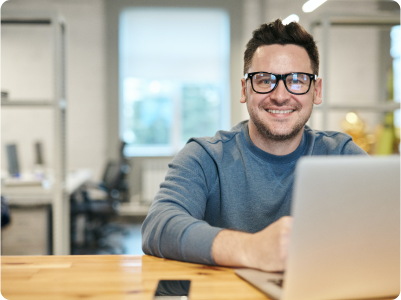 Man smiling and working on laptop
