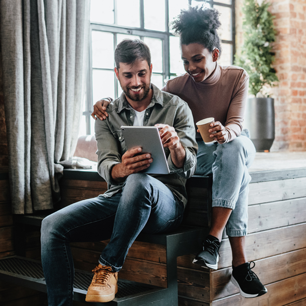 Young couple looking at tablet together smiling