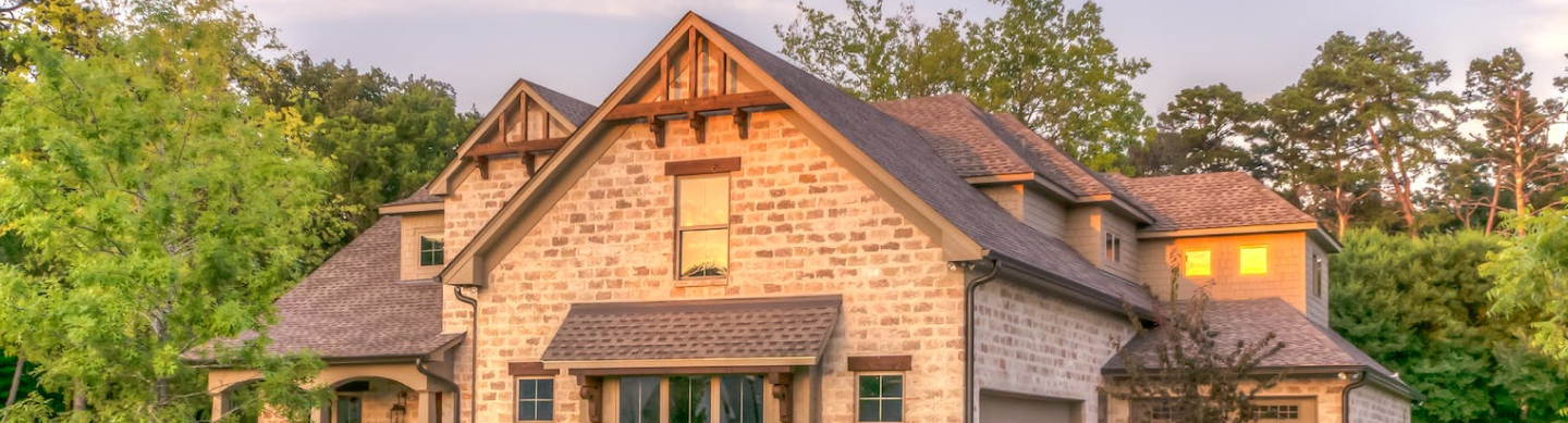 Large house surrounded by tres during sunrise